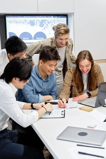 Focused group working on business strategy with laptop and charts at modern workplace.